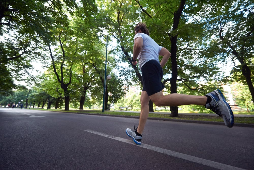healthy athlete man jogging at morning on empty roat in the city